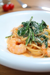 A Plate Of Shrimp And Spinach Spaghetti With Thousand Island dressing