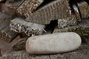 Gray smooth stone on the wooden boards. Abstract background. Close up view.