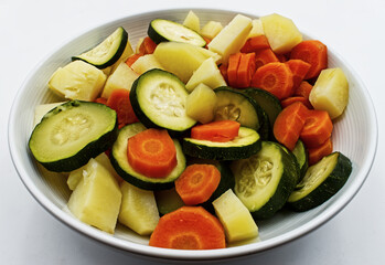 Vegetables salad with zucchini, carrots and patatoes in a bowl.