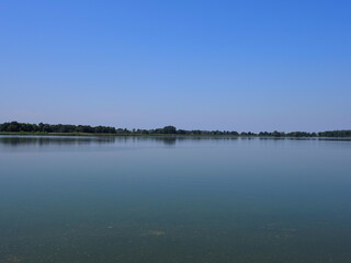 Scenic artificial pond in european Goczalkowice town at Silesian district in Poland, clear blue sky in 2020 warm sunny spring day on June.