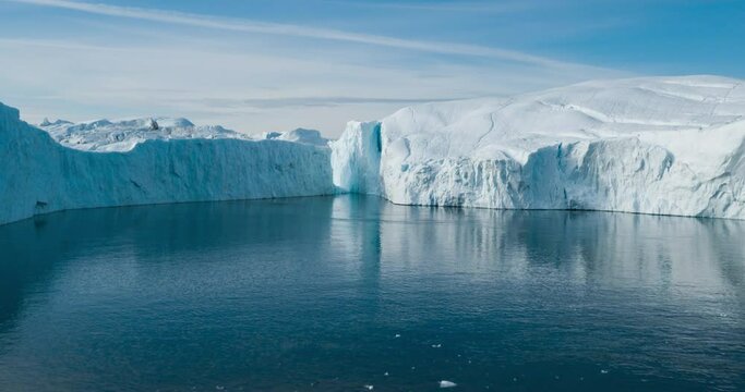 Climate change - Greenland Iceberg landscape of Ilulissat icefjord with giant icebergs. Timelapse hyperlapse with Icebergs from melting glacier. Arctic nature heavily affected by Global warming