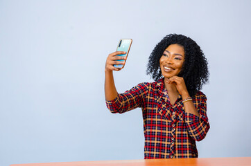 a young beautiful african american lady feeling excited about what she was on her cellphone