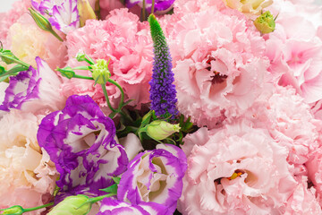 Pink and purple bouquet of flowers in a pink box isolated on white.