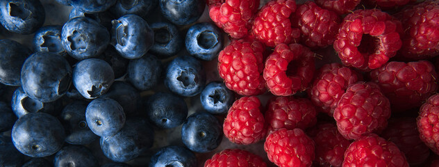 Closeup top view pile of fresh blueberries and raspberries
