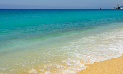Fototapeta na wymiar blue sea, white wave and clean sand on the cleopatra beach in alanya 