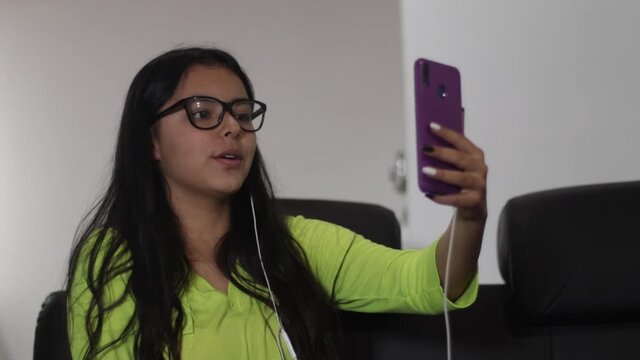 mujer joven ni&ntilde;a hablando por celular en videollamada con amigos y familiares, comunicaci&oacute;n en cuarentena Covid 19 aislamiento