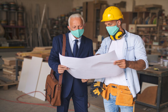 Carpenter showing his ideas to businessman