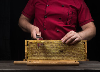 The chef cuts the honeycomb with a knife. The concept of using a healthy product in cooking.
