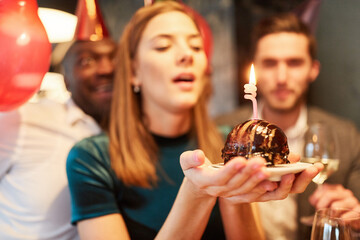 Woman blowing out the candle on a celebration