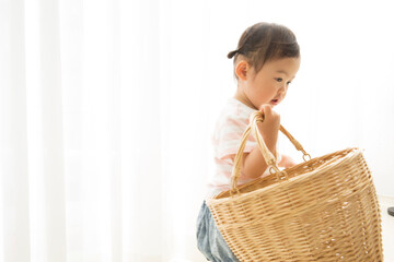 かごで遊ぶ幼児