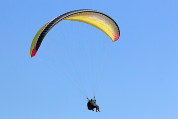Tandem Paraglider flying wing in a blue sky	
