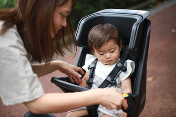 自転車に子供を乗せる母親