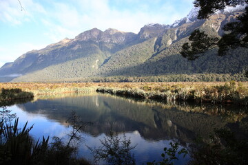 View of Mirror lakes and crystal-clear reflections on a still day during Winter in Fiordland National park New Zealand