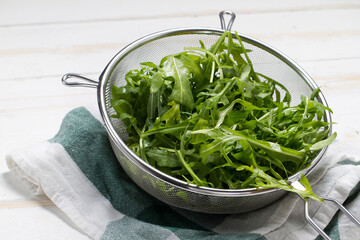 Washed arugula in a steel sieve