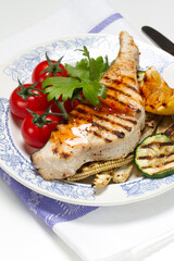 Grilled swordfish steak, young corn, zucchini, lemon, cherry tomatoes, chili sauce and celery leaf