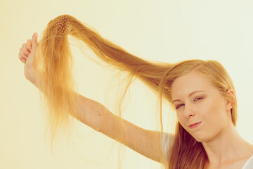 Fototapeta premium Blonde girl brushing her long hair