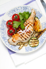 Grilled swordfish steak, young corn, zucchini, lemon, cherry tomatoes, chili sauce and celery leaf