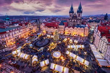Panorama des alten Dorfplatzes in der Altsatdt von Prag, Tschechiche Republik, mit Weihnachtsmarkt und bunten Adventslichtern zur festlichen Weihnachtszeit