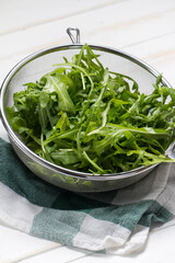 Washed arugula in a steel sieve