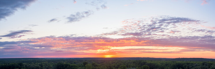 panorama of a blue-pink sunset with clouds of pink hues. sunset on the horizon. photo for the banner. space for text.