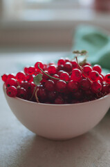 Bright fresh red currant in ivory bowl in morning light 