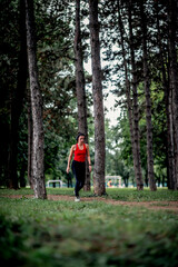 Obraz premium Young sporty woman jogging through the forest