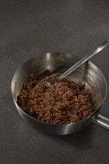 Dinkel Risotto in kleinem Stiel Topf auf dunklem Stein Tisch 