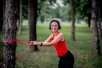 Woman exercising with elastic band outdoors 