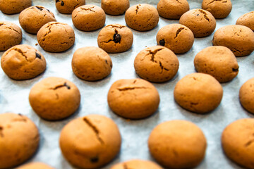 Homemade chocolate chip cookies or biscuits on baking sheet. Selective focus.