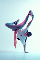 Young breakdancer guy stands on one hand dancing hip-hop in neon light. Dance school poster