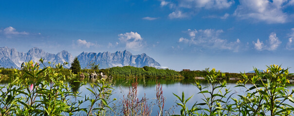 Speichersee am Hahnenkamm in Kitzbühl, mit dem Kaisergebirge im Hintergrund