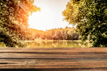 Wooden desk of free space and autumn landscape of lake 