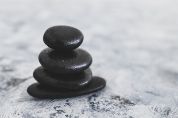 meditation inspired image with  stack of zen pebbles on grey concrete surface.