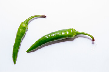 Fresh, green chili peppers on a white background