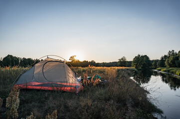 Fototapeta na wymiar tent at sunset by the river, mosquito net,