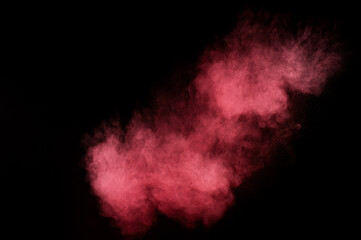 Red and pink powder explosion on black background. Colored powder cloud. Colorful dust explode. Paint Holi.