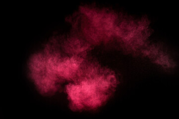Red and pink powder explosion on black background. Colored powder cloud. Colorful dust explode. Paint Holi.