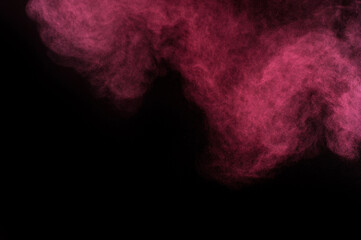 Red and pink powder explosion on black background. Colored powder cloud. Colorful dust explode. Paint Holi.