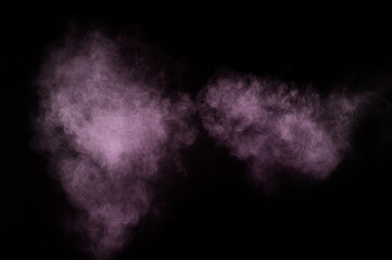 Purple powder explosion on black background. Colored powder cloud. Colorful dust explode. Paint Holi.
