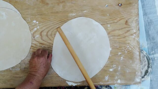 Woman rolls out dough, close-up. Making Turkish traditional bread top view