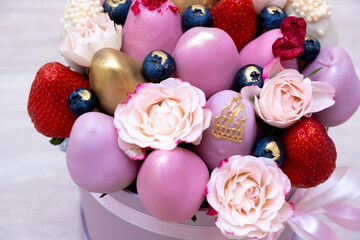 delicious bouquet of strawberries in white, pink and gold chocolate on a light background.