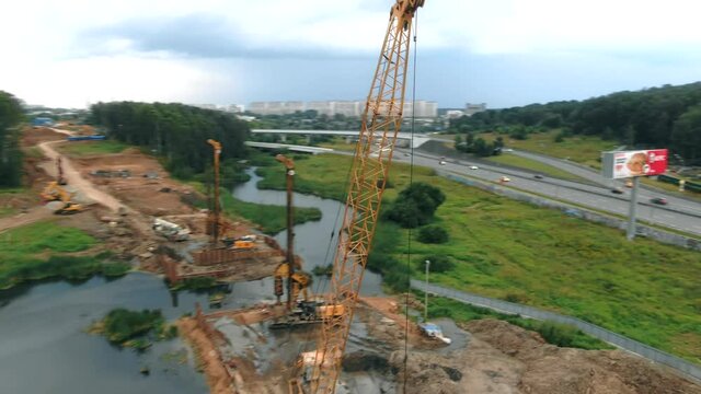 Aerial view of a crawler crane on a construction site by the river