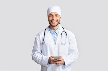 Professional medical doctor with cellphone, smiling at camera