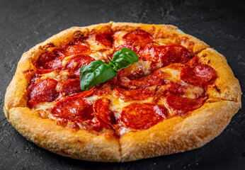 Pepperoni Pizza with Mozzarella cheese, salami, Tomato sauce, pepper, Spices. Italian pizza on Dark grey black slate background