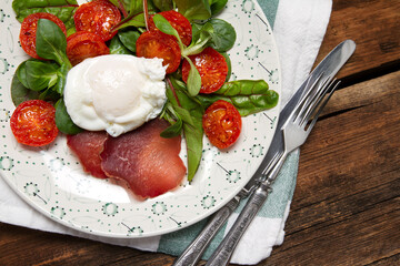 Poached egg with salad, bresaola and stewed cherry tomatoes