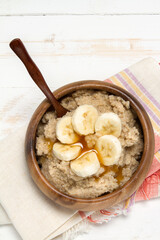 Healthy breakfast: oat bran porridge, banana and agave syrup