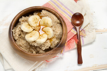 Healthy breakfast: oat bran porridge, banana and agave syrup