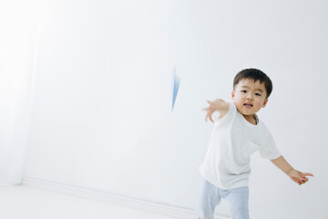 紙ひこうきで遊ぶ幼児