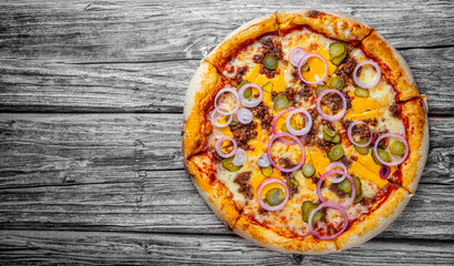 Pizza with Mozzarella cheese, Bolognese sauce, minced meat and vegetables. Italian pizza on wooden background.