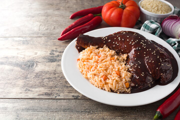Traditional mole Poblano with rice in plate on wooden table. Copy space	